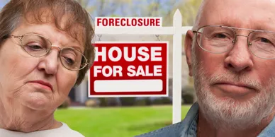 Sad couple in front of a foreclosure house for sale sign